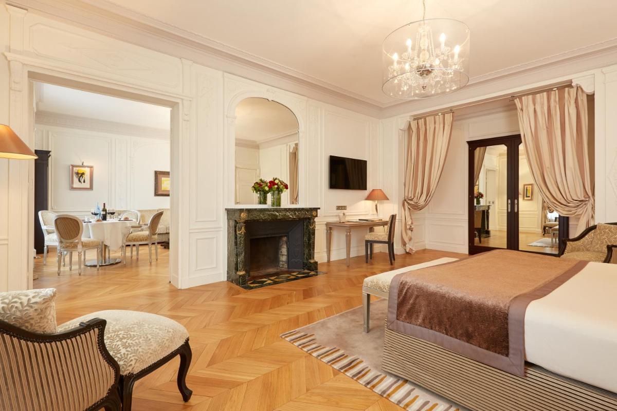 une chambre avec un lit et une cheminée dans l'établissement Majestic Apartments Champs Elysées, à Paris