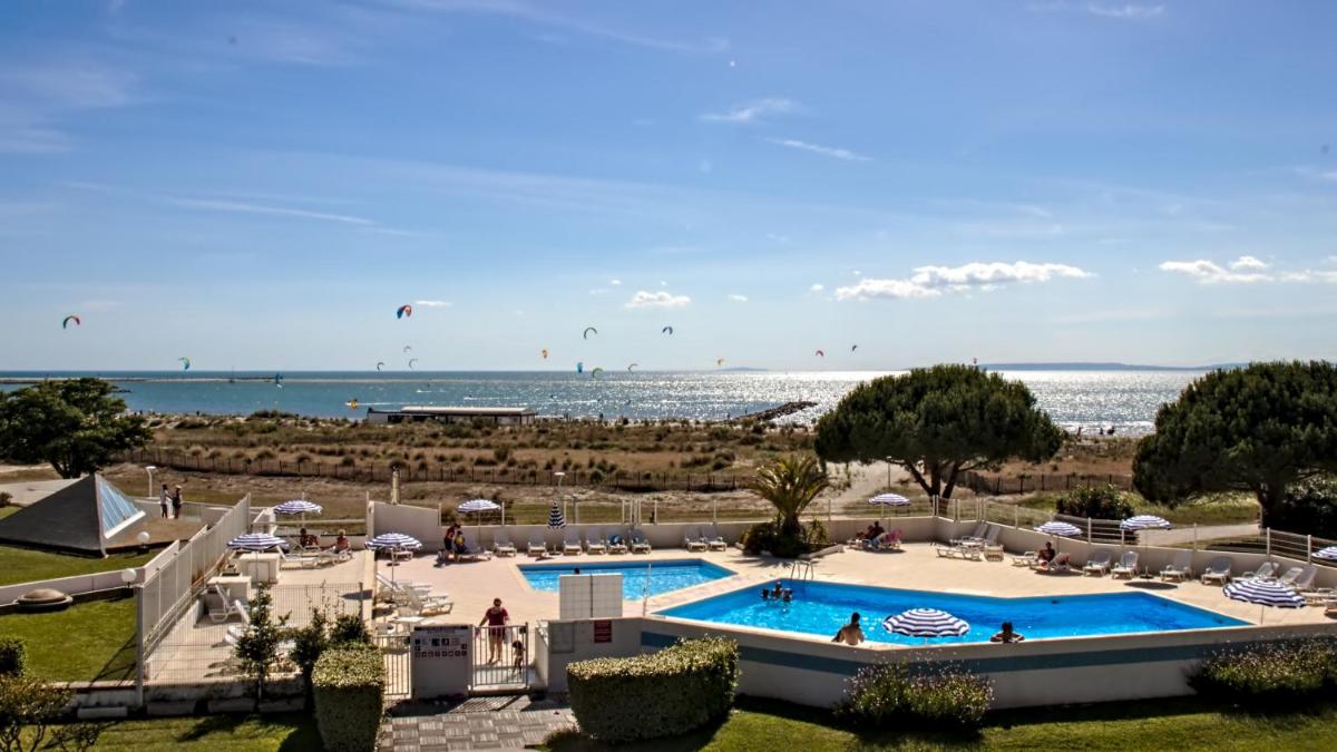 un complexe avec piscine et plage dans l'établissement Residence Ulysse Port Camargue, au Grau-du-Roi