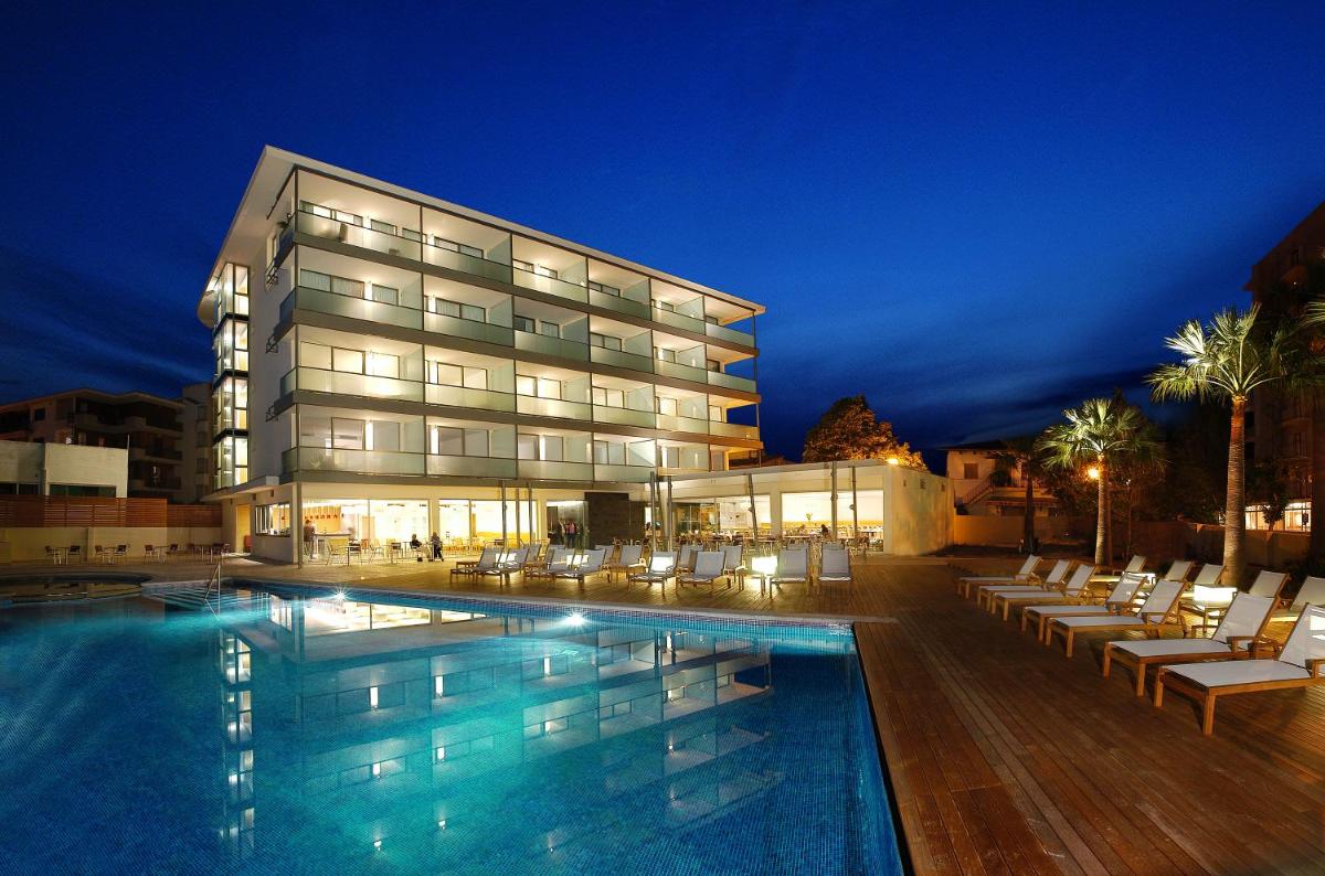 un hotel con piscina frente a un edificio en Aimia Hotel, en Puerto de Sóller