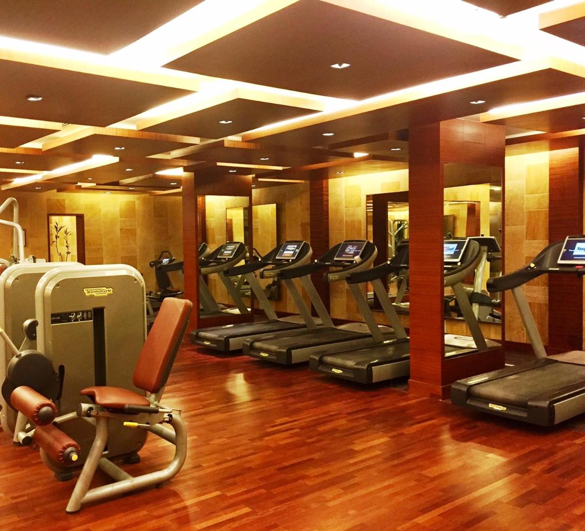 a gym with a bunch of treadmills in a room at Jaypee Palace Hotel in Agra