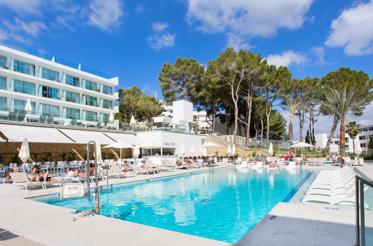 Una piscina con tumbonas y un hotel. en Reverence Life Hotel - Adults Only, en Santa Ponsa