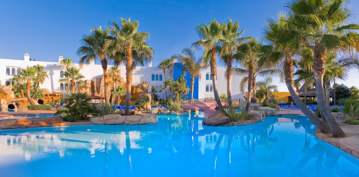 una piscina con palmeras en un complejo en Playaballena, en Costa Ballena
