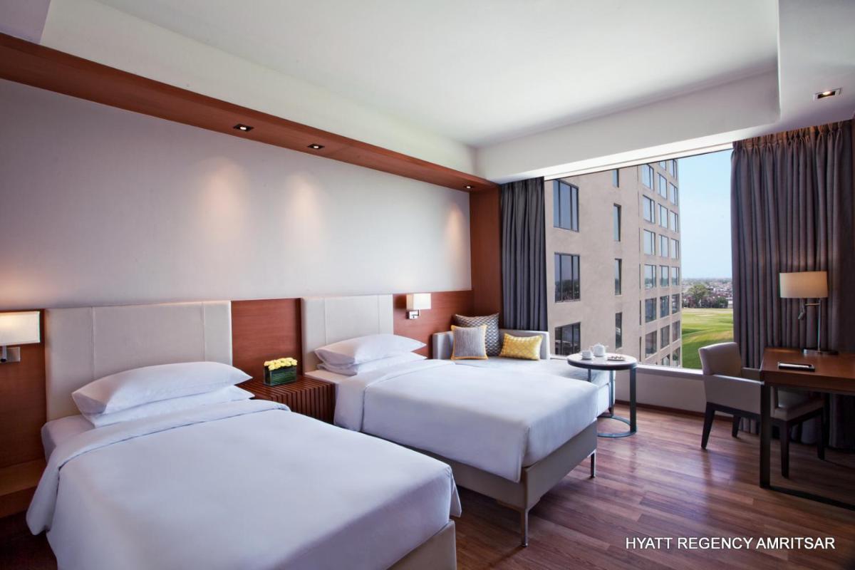 a hotel room with two beds and a window at Hyatt Regency Amritsar Hotel & Spa in Amritsar