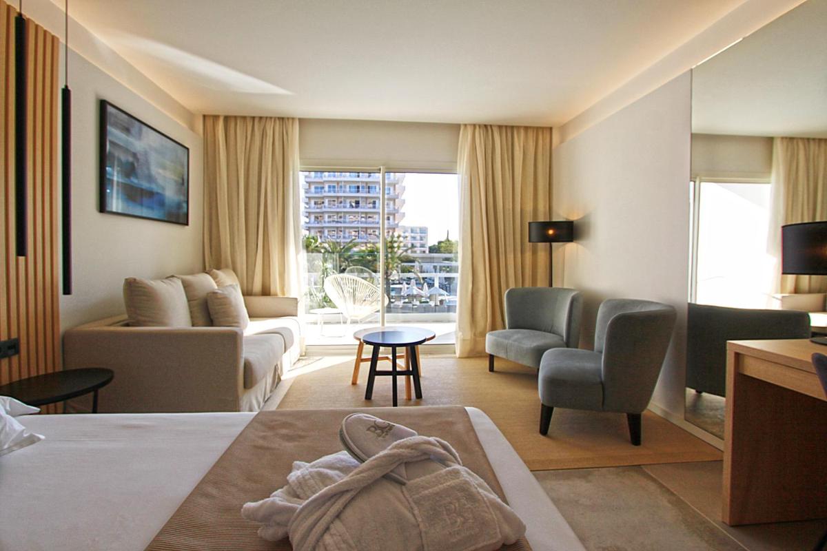 Una habitación de hotel con una cama y una sala de estar. en BG Caballero, en Playa de Palma