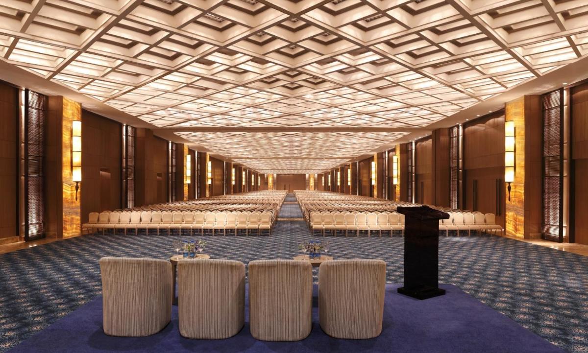 a large room with tables and chairs in it at The Leela Ambience Convention Hotel Delhi in New Delhi