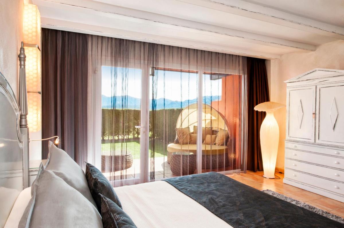Un dormitorio con una cama y una puerta corrediza de vidrio. en Mas Tapiolas, en Santa Cristina d'Aro