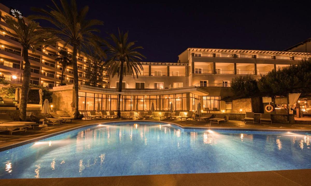 Una gran piscina frente a un edificio por la noche. en Be Live Adults Only La Cala Boutique Hotel, en Palma de Mallorca
