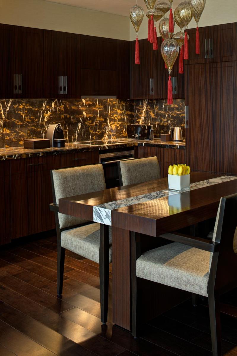 a kitchen with a wooden table and chairs at Park Hyatt Hotel and Residences, Hyderabad in Hyderabad