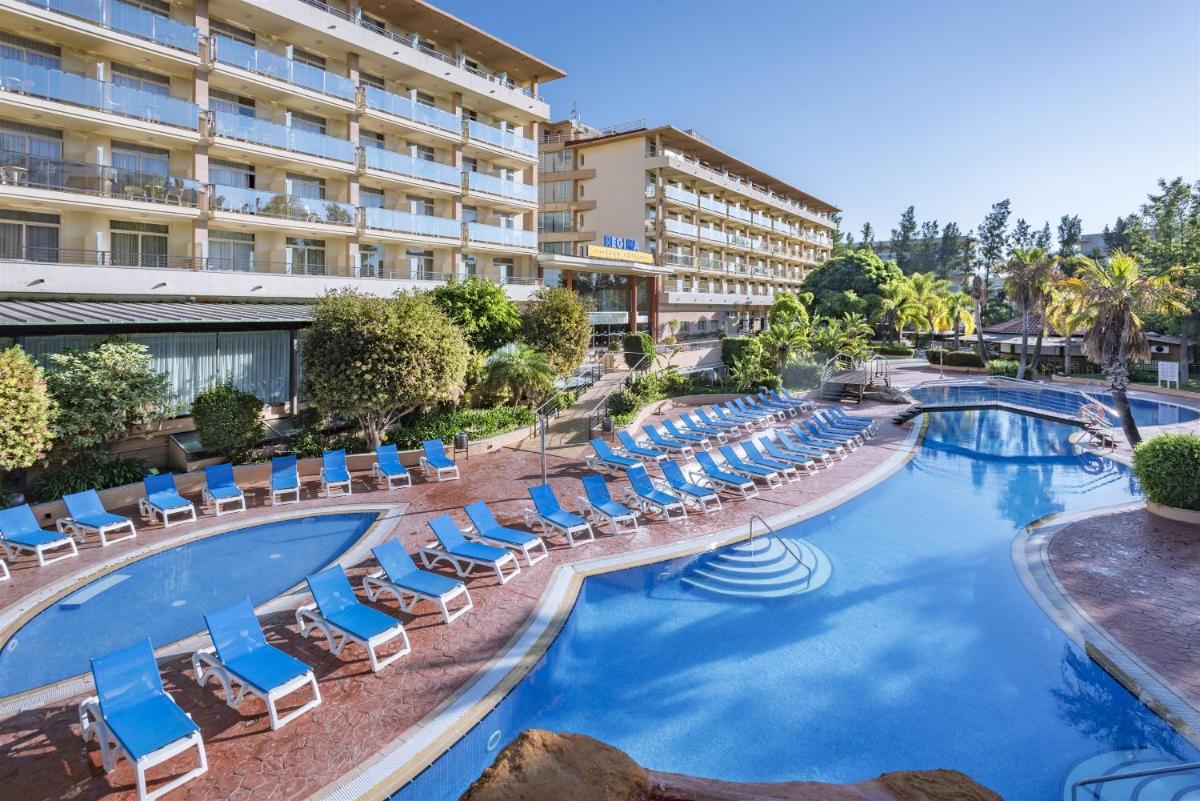 Una piscina con tumbonas y un hotel. en 4R Gran Regina, en Salou