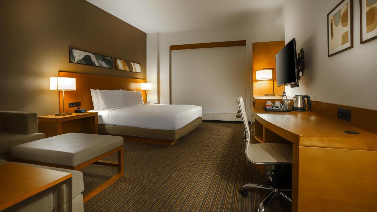 a hotel room with a bed and a desk at Hyatt Place Gurgaon Udyog Vihar in Gurgaon