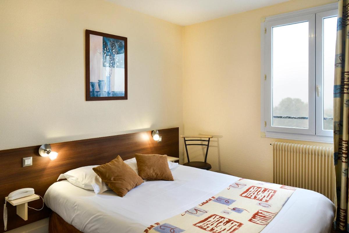 Un ou plusieurs lits dans un hébergement de l'établissement Logis Hotel Spa Restaurant Au Site Normand
