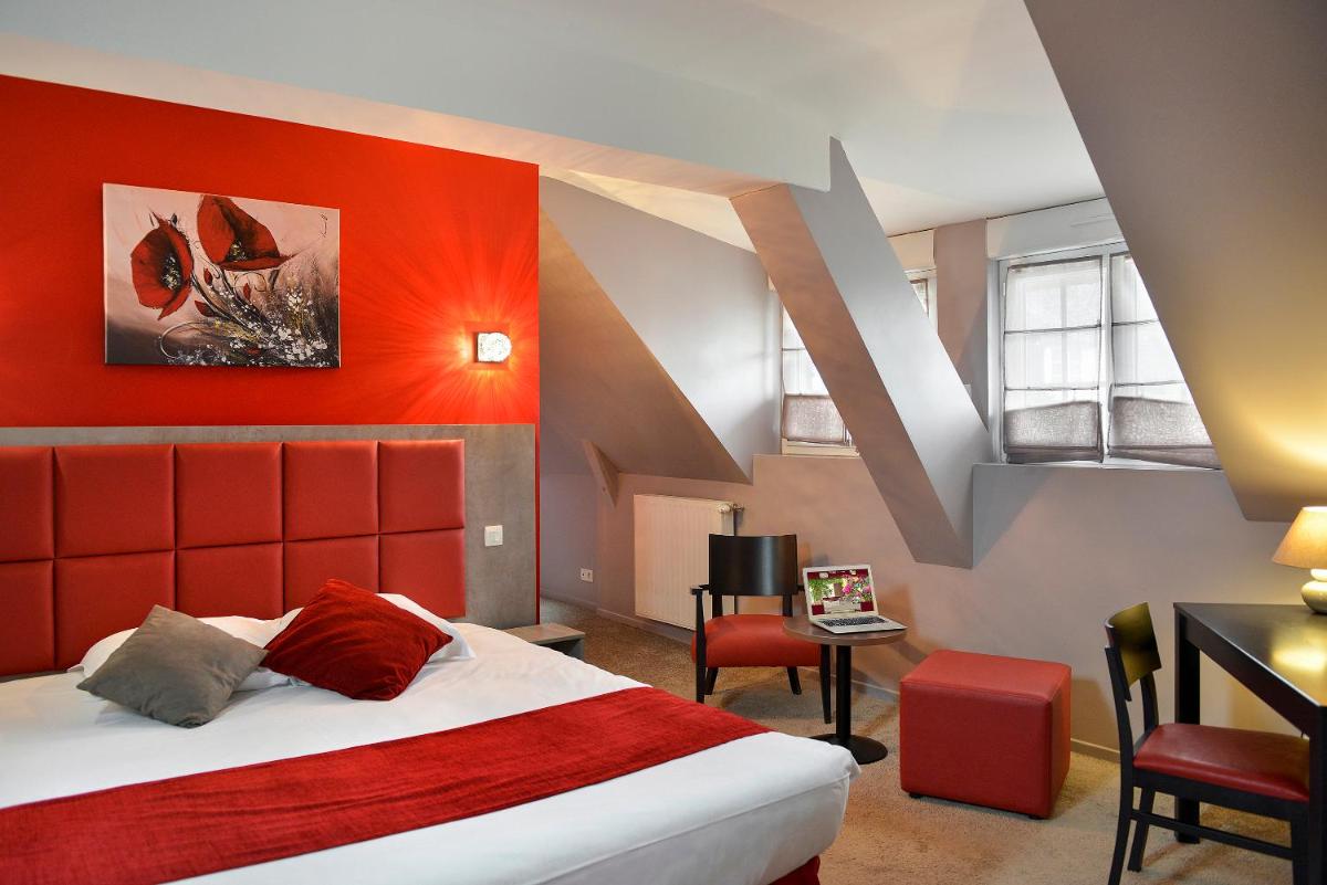 une chambre avec un grand lit avec une tête de lit rouge dans l'établissement Logis Hotel Spa Restaurant Au Site Normand, à Clécy