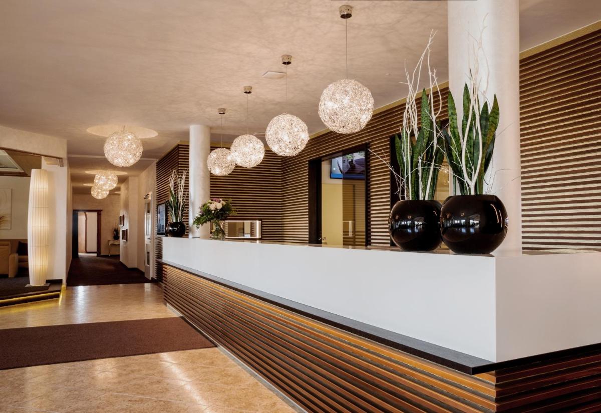 eine Lobby mit einer Theke mit Vasen darauf in der Unterkunft Der Birkenhof Spa & Genuss Resort in Hofenstetten + 37 Fotos