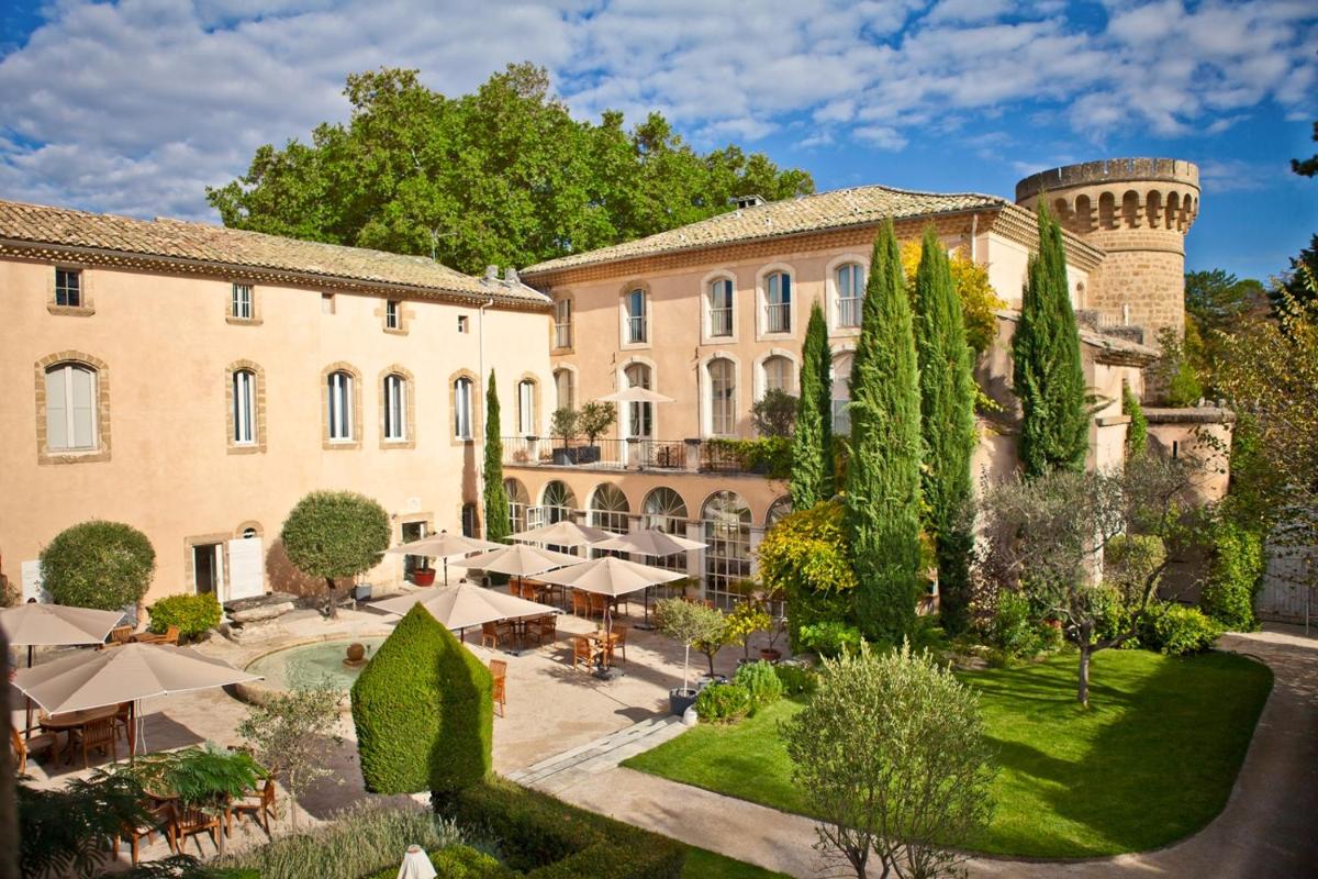 une vue extérieure d'un bâtiment avec une cour dans l'établissement Château De Massillan, à Uchaux