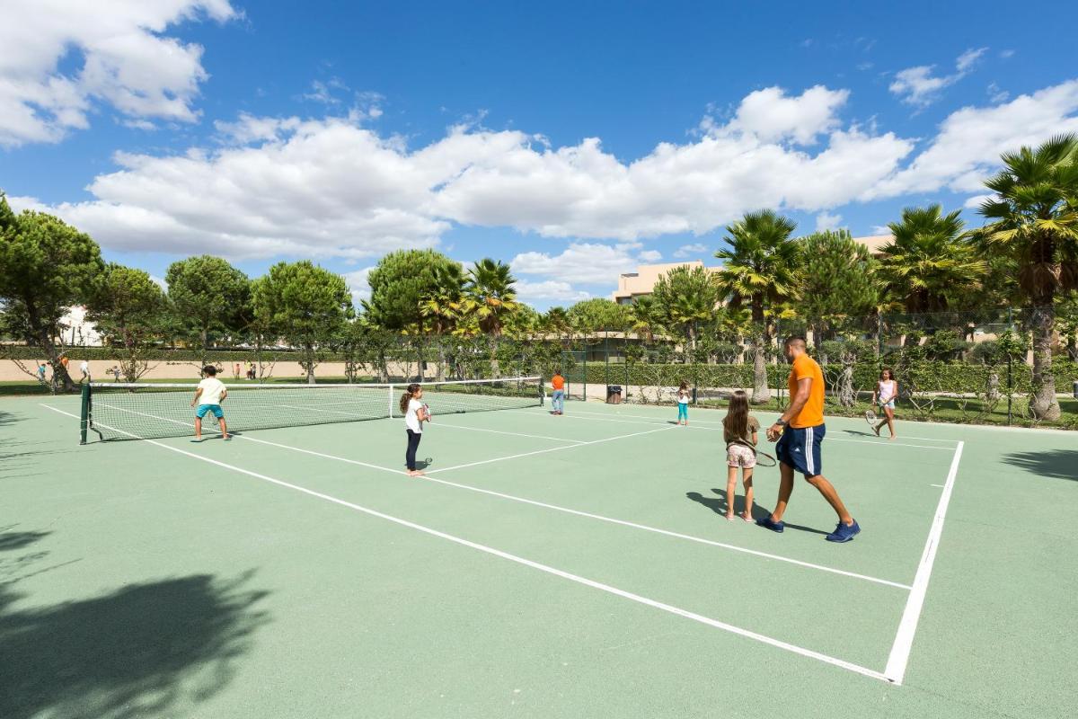 um grupo de pessoas a jogar ténis num campo de ténis em NAU Sao Rafael Suites - All Inclusive em Albufeira