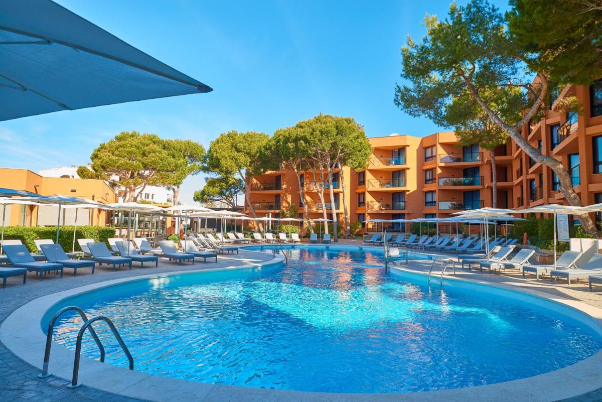 una piscina con sillas y sombrillas en un hotel en Protur Turo Pins 4* SUP, en Cala Ratjada