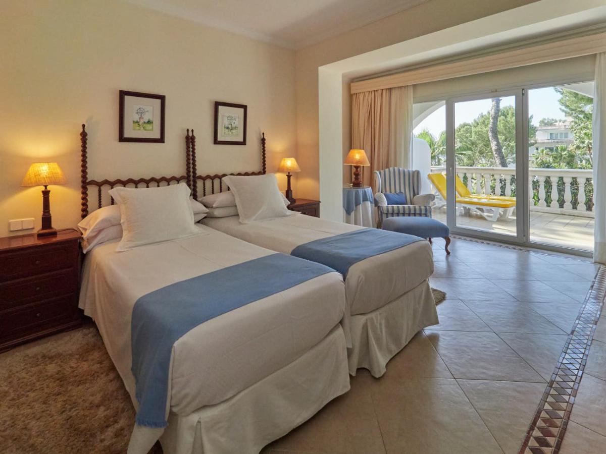 Una habitación de hotel con dos camas y balcón. en Hotel Bon Sol Resort & Spa, en Illetas