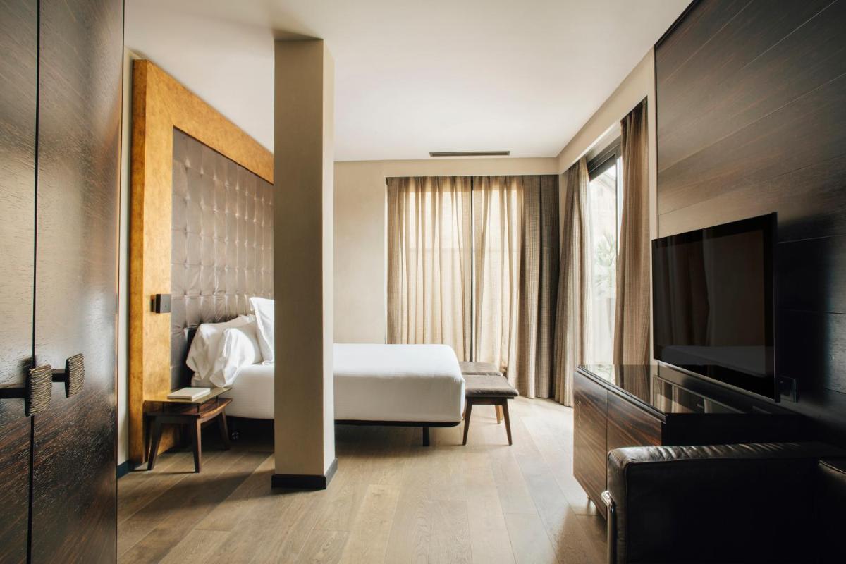 una habitación de hotel con una cama y un televisor en Hotel Bagués, a Small Luxury Hotel of the World, en Barcelona