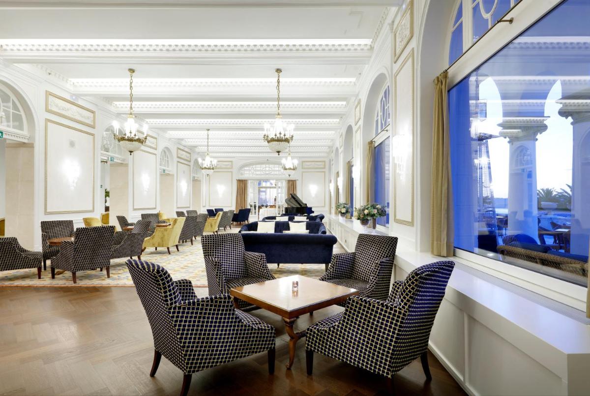 Una sala de espera con sillas y una mesa en un edificio. en Eurostars Hotel Real, en Santander