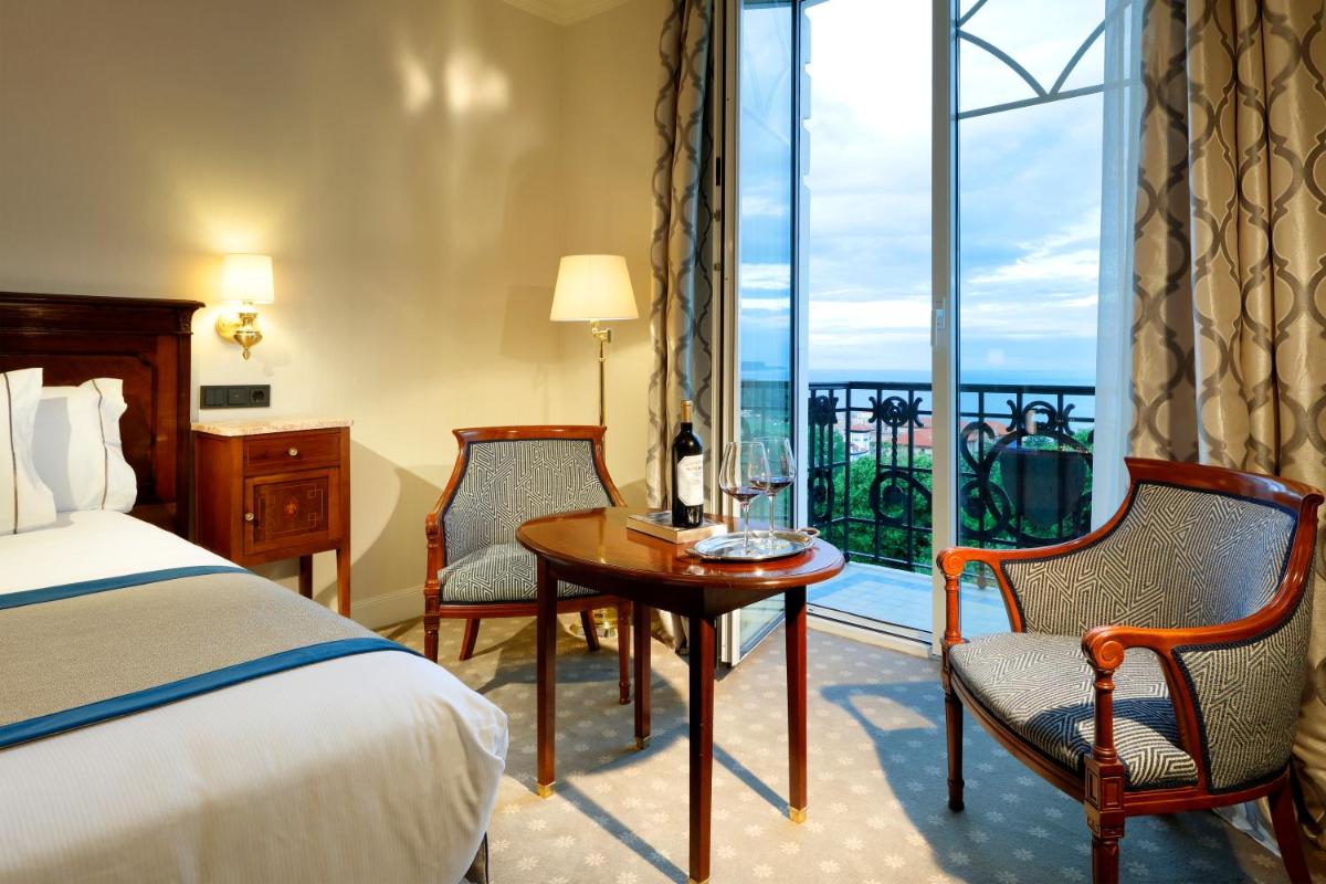 Una habitación de hotel con una cama, una mesa y sillas. en Eurostars Hotel Real, en Santander