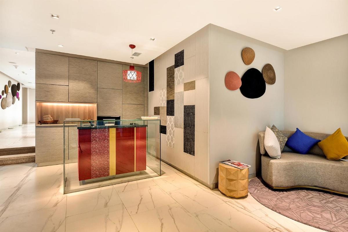 a living room with a couch and a kitchen at Welcomhotel by ITC Hotels, RaceCourse, Coimbatore in Coimbatore