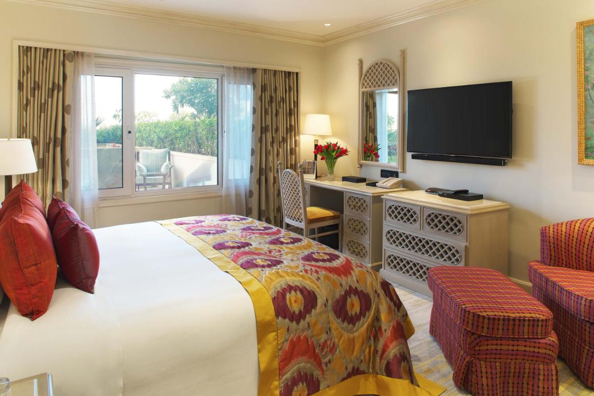 a hotel room with a bed and a television at Taj Palace, New Delhi in New Delhi a hotel room with a bed and a television at Taj Palace, New Delhi in New Delhi