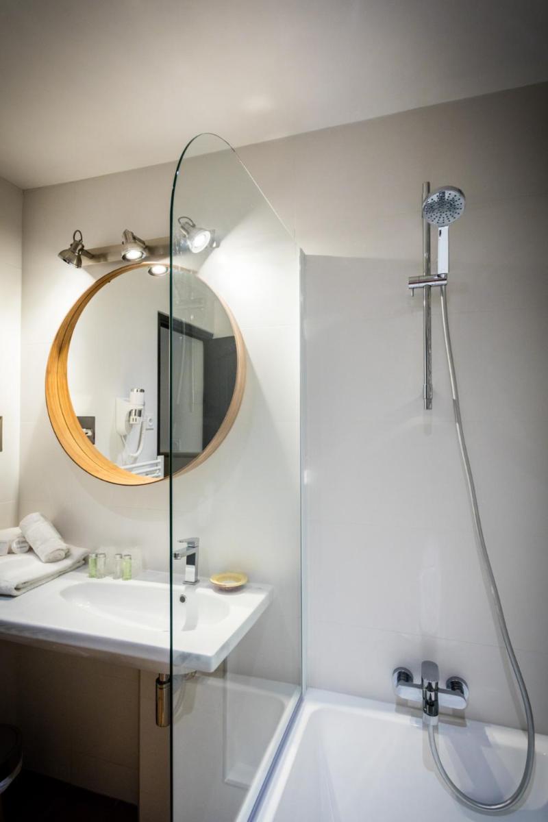 une salle de bains avec douche, lavabo et miroir dans l'établissement Oustau Camarguen Hôtel & Spa, au Grau-du-Roi