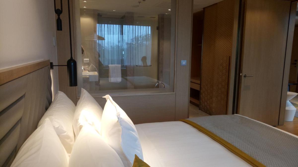 a bedroom with a bed and a bathroom with a tub at Welcomhotel by ITC Hotels, RaceCourse, Coimbatore in Coimbatore