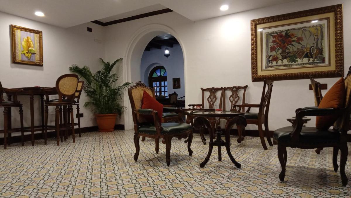 a room with chairs and a table and a painting at Forte Kochi in Cochin