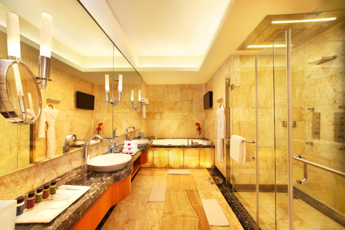a bathroom with two sinks and a shower at Gokulam Grand Hotel & Spa Bangalore in Bengaluru a bathroom with two sinks and a shower at Gokulam Grand Hotel & Spa Bangalore in Bengaluru