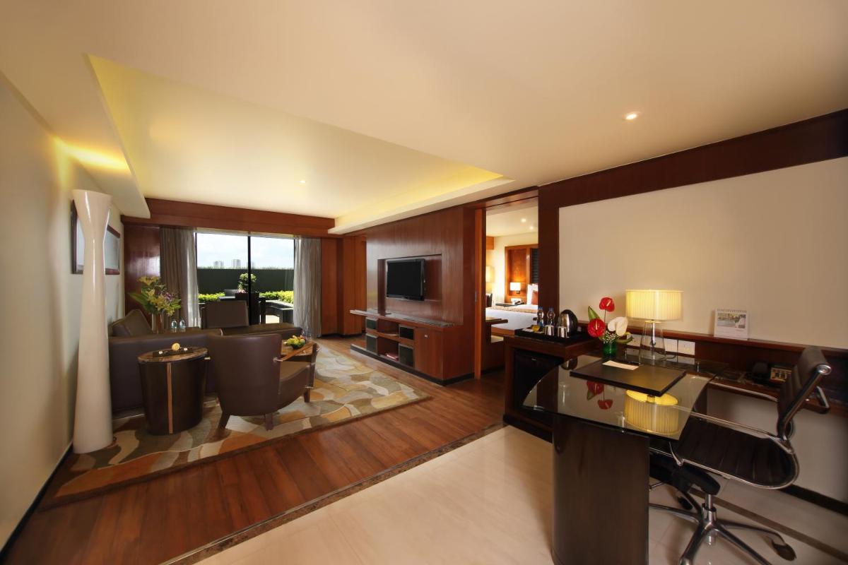 a living room with a couch and a television at Gokulam Grand Hotel & Spa Bangalore in Bengaluru a living room with a couch and a television at Gokulam Grand Hotel & Spa Bangalore in Bengaluru