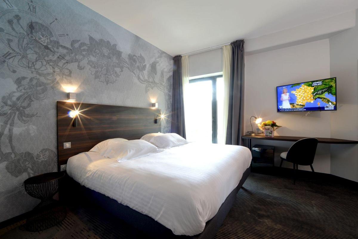 Un ou plusieurs lits dans un hébergement de l'établissement Logis Hôtel Victor Hugo & Spa