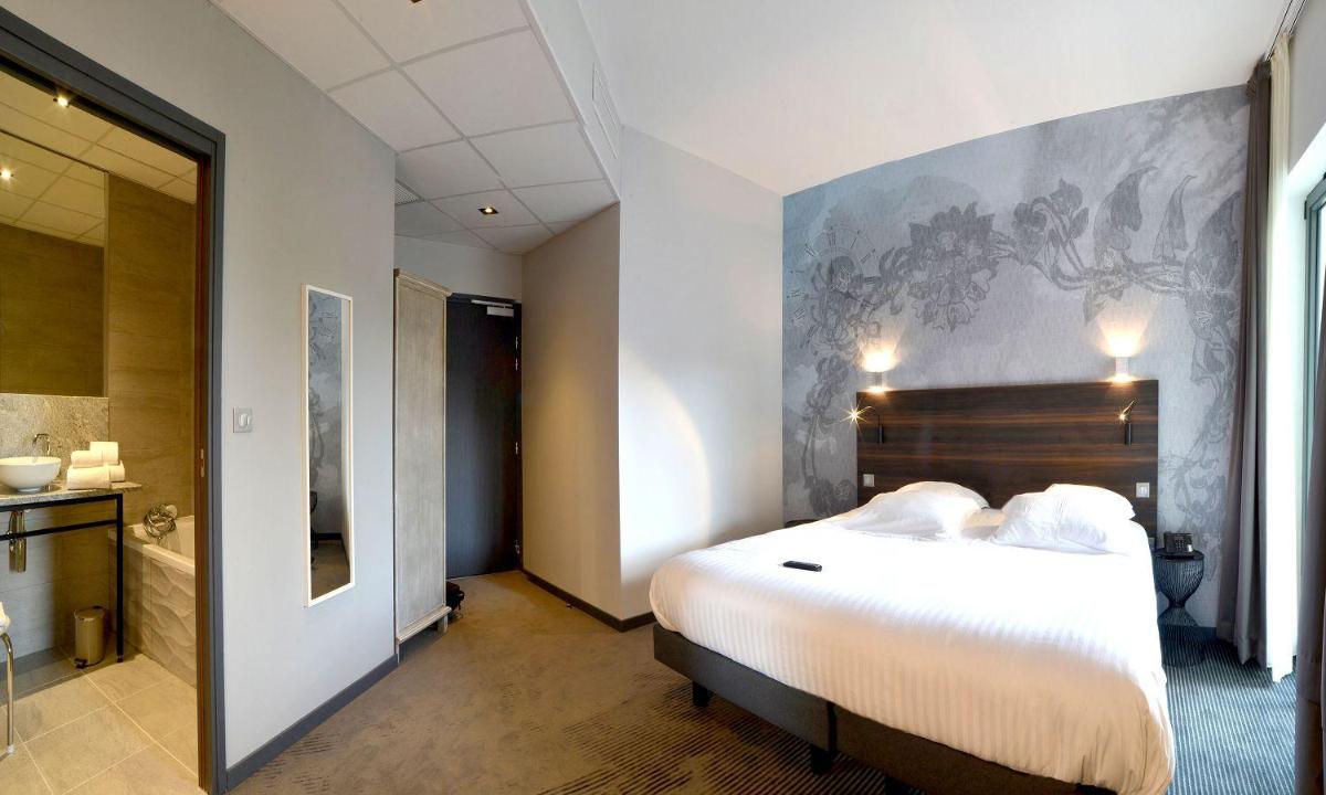 Un ou plusieurs lits dans un hébergement de l'établissement Logis Hôtel Victor Hugo & Spa