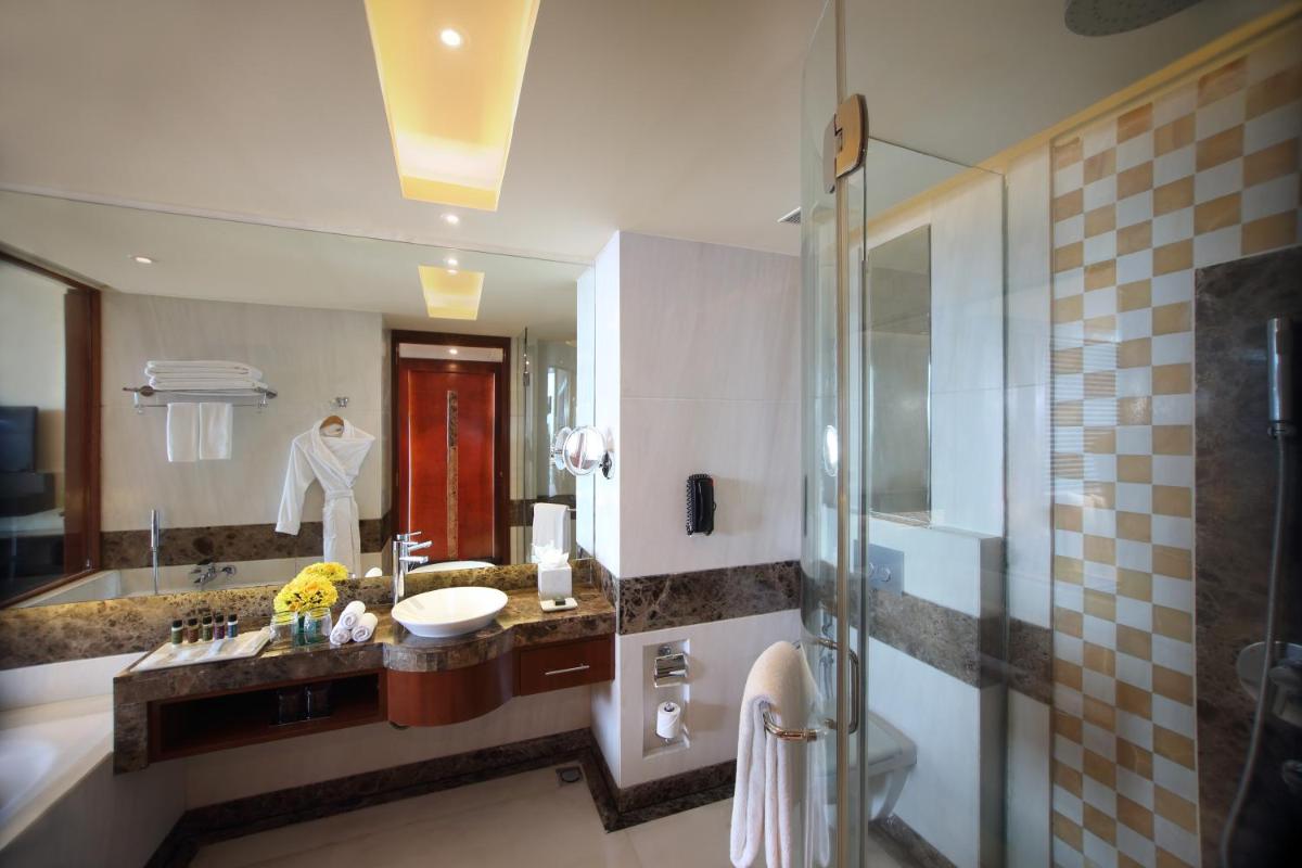 a bathroom with a sink and a shower at Gokulam Grand Hotel & Spa Bangalore in Bengaluru a bathroom with a sink and a shower at Gokulam Grand Hotel & Spa Bangalore in Bengaluru