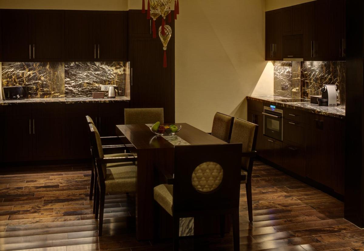 a kitchen and dining room with a table and chairs at Park Hyatt Hotel and Residences, Hyderabad in Hyderabad