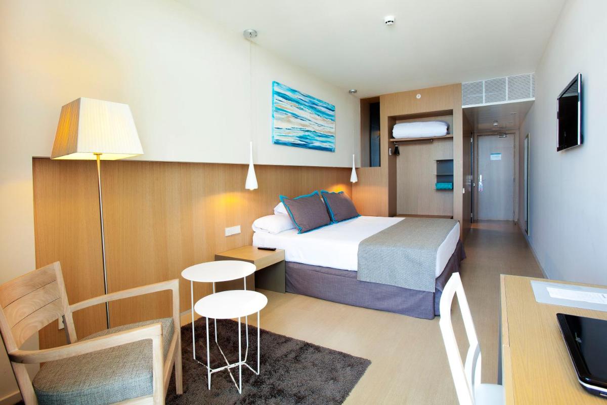 Una habitación de hotel con una cama, una mesa y sillas. en Atenea Port Barcelona Mataró, en Mataró 59 fotos más