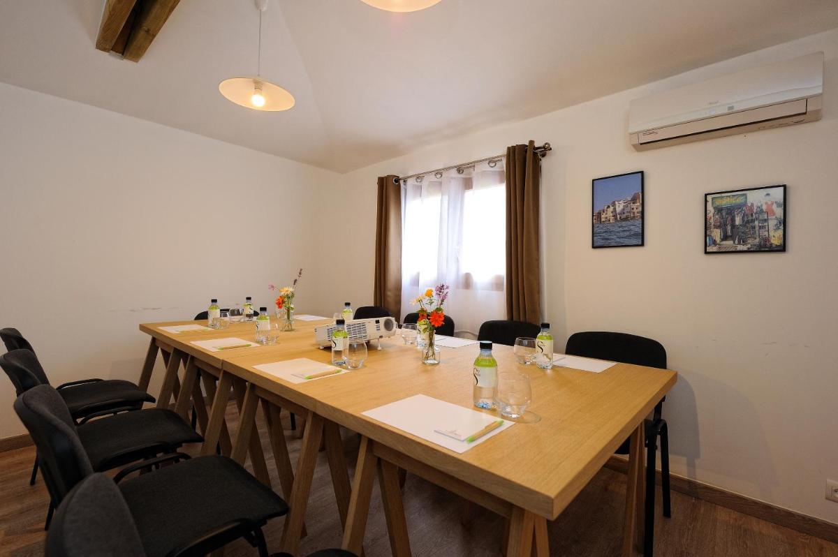 une salle de conférence avec une longue table en bois et des chaises dans l'établissement Lodge de Charme A Cheda, à Bonifacio 54 autres photos