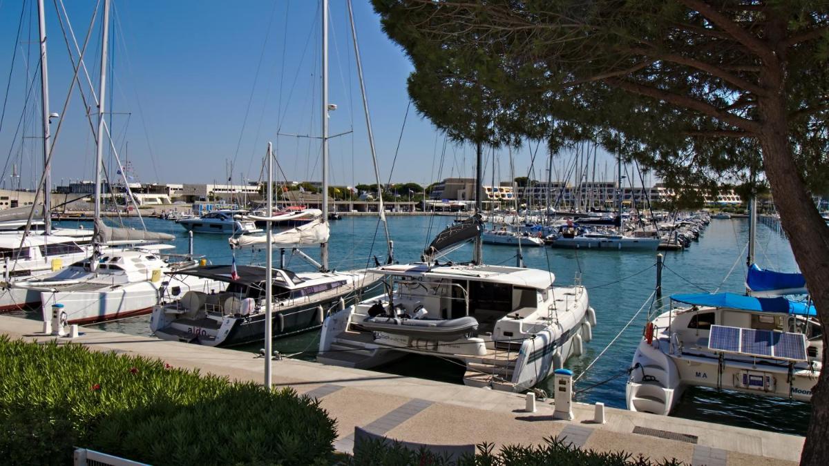 un groupe de bateaux amarrés dans une marina dans l'établissement Rivages d'Ulysse Port Camargue, au Grau-du-Roi