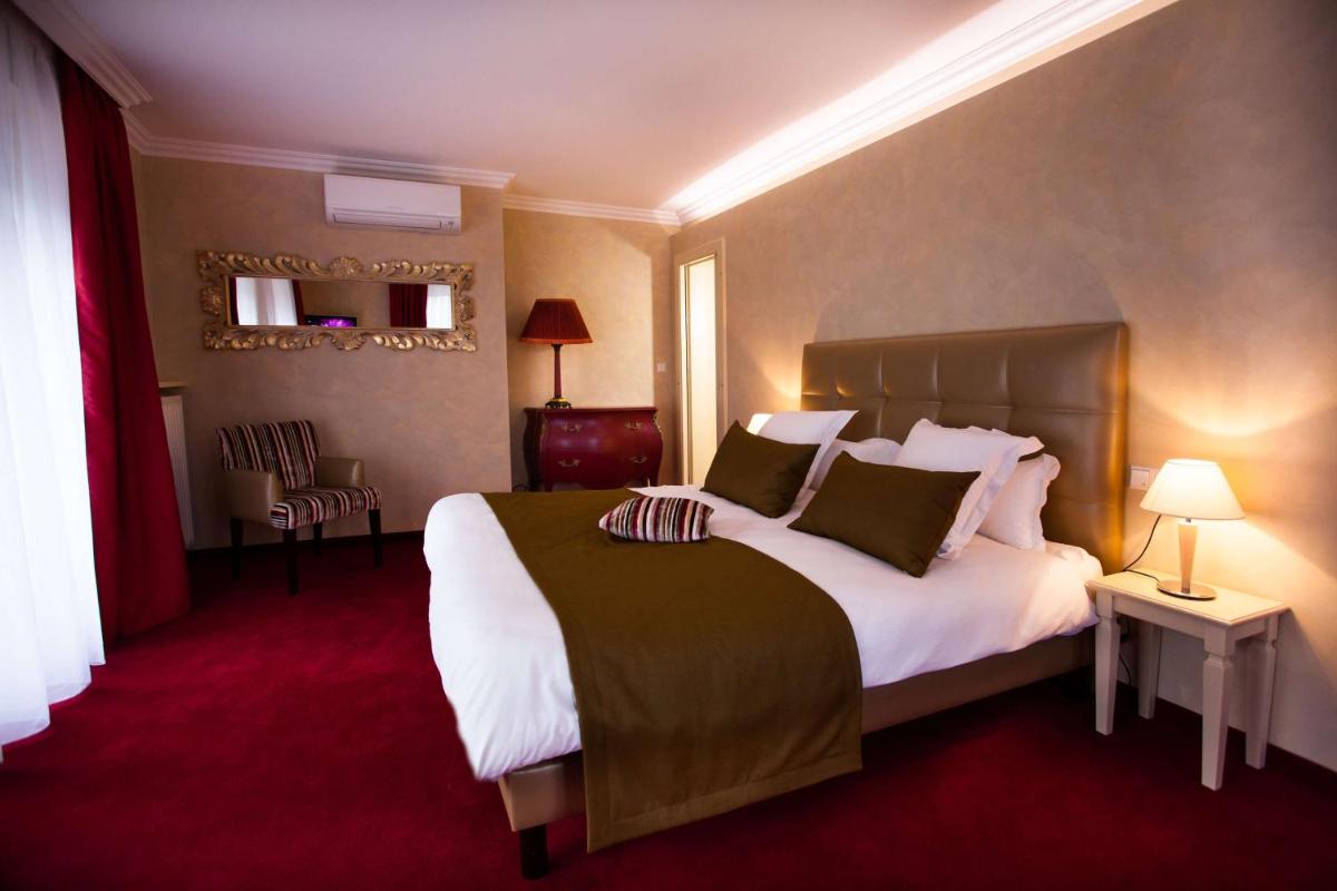 Un ou plusieurs lits dans un hébergement de l'établissement Les Violettes Hotel & Spa