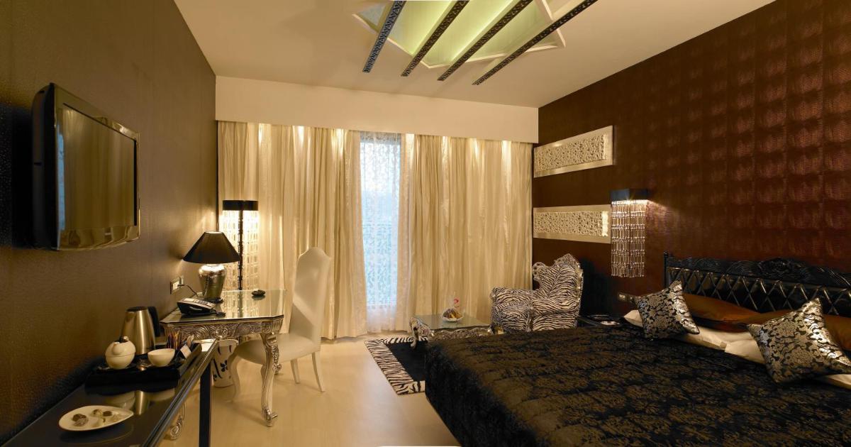 a bedroom with a large bed and a large window at The Zuri Whitefield Bengaluru in Bengaluru
