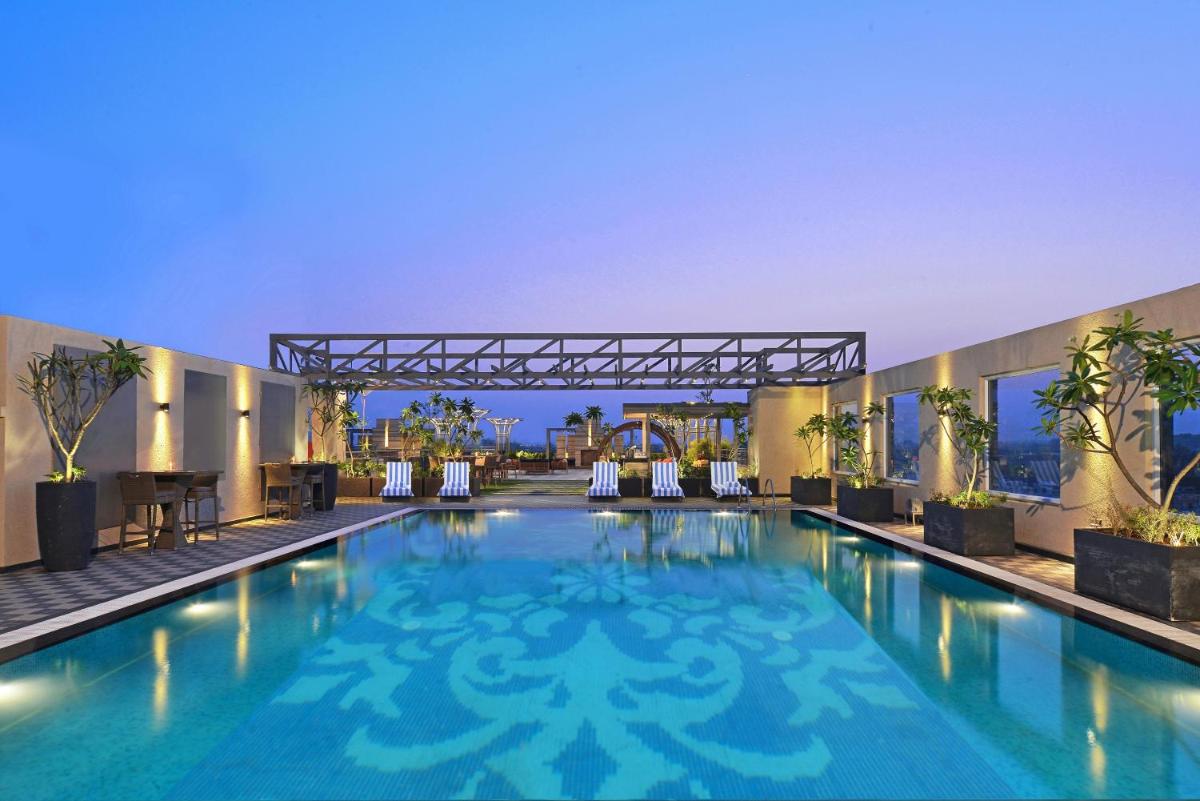 a large swimming pool with blue water in a building at Radisson Chandigarh Zirakpur in Chandīgarh