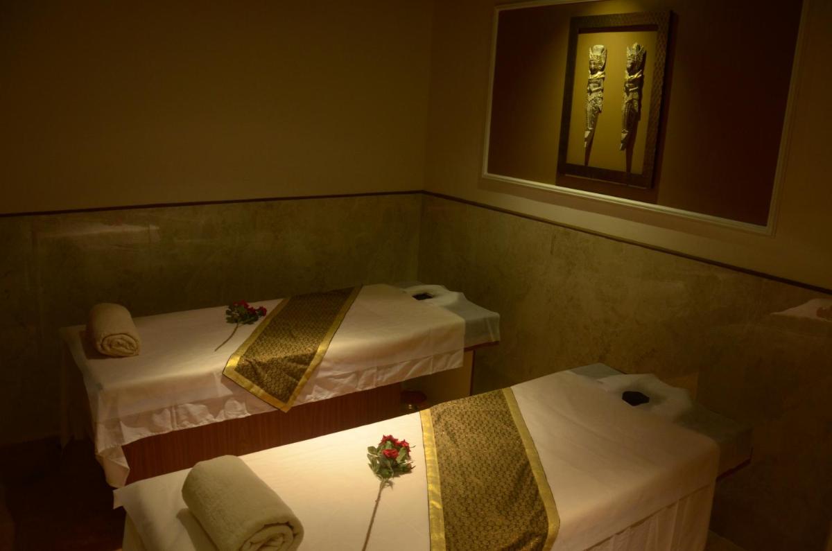 a small bathroom with two beds and a mirror at Ramada Plaza Chennai in Chennai
