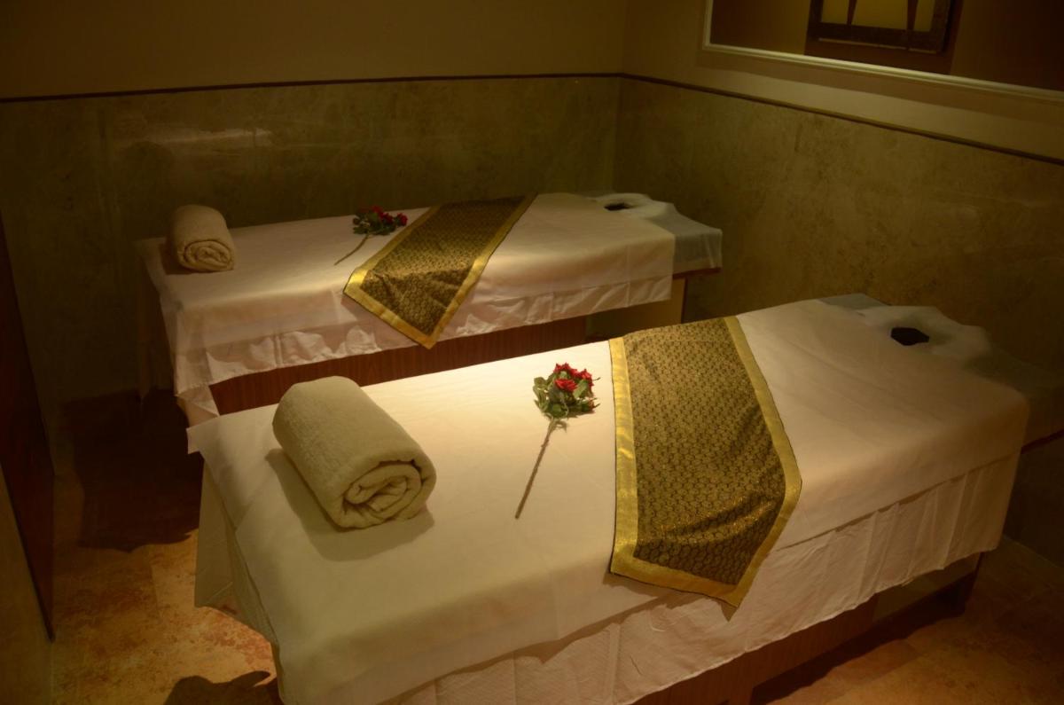 two beds in a room with towels and flowers on them at Ramada Plaza Chennai in Chennai