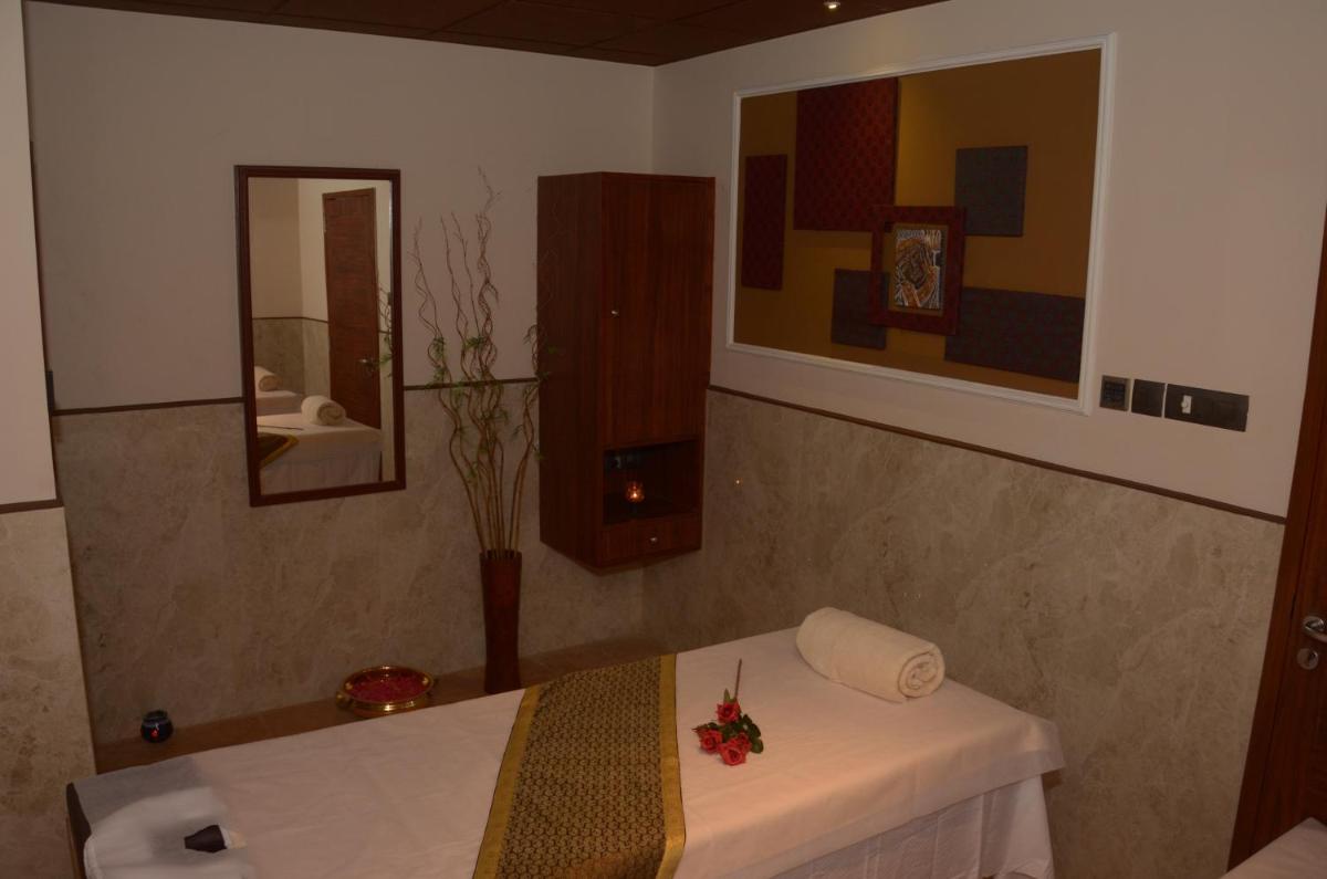 a room with a white table and a mirror at Ramada Plaza Chennai in Chennai