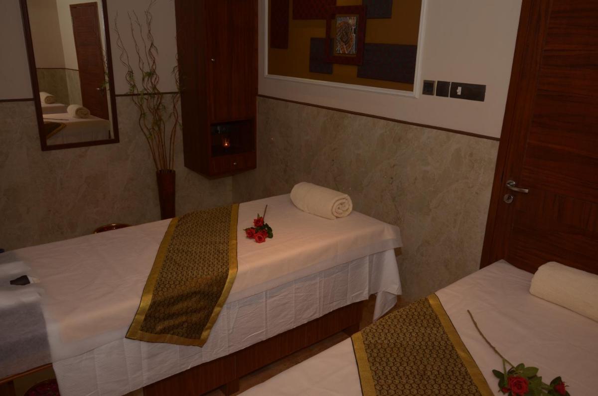 a room with two beds with white sheets and flowers on it at Ramada Plaza Chennai in Chennai