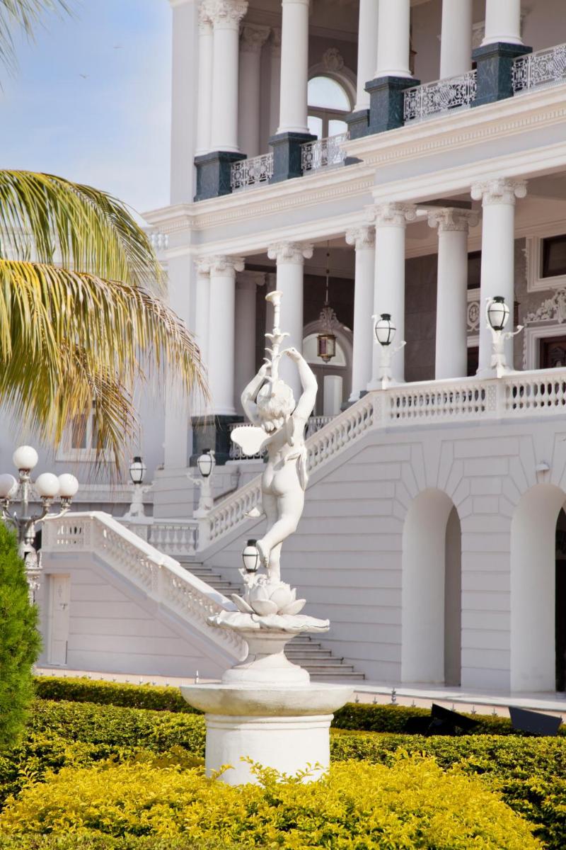 a statue in front of a white building at Taj Falaknuma Palace in Hyderabad