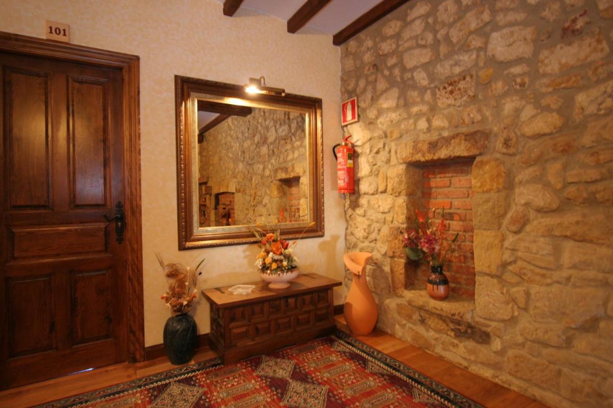 sala de estar con chimenea de piedra y espejo en Hotel "Posada de Cantabria EL SOLAR" -Cenas típicas y Gintonic- Bar -Terraza panorámica, en Galizano