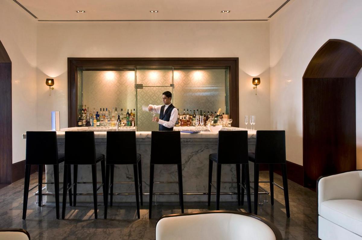 a man standing behind a bar in a restaurant at The Taj Mahal Tower, Mumbai in Mumbai a man standing behind a bar in a restaurant at The Taj Mahal Tower, Mumbai in Mumbai
