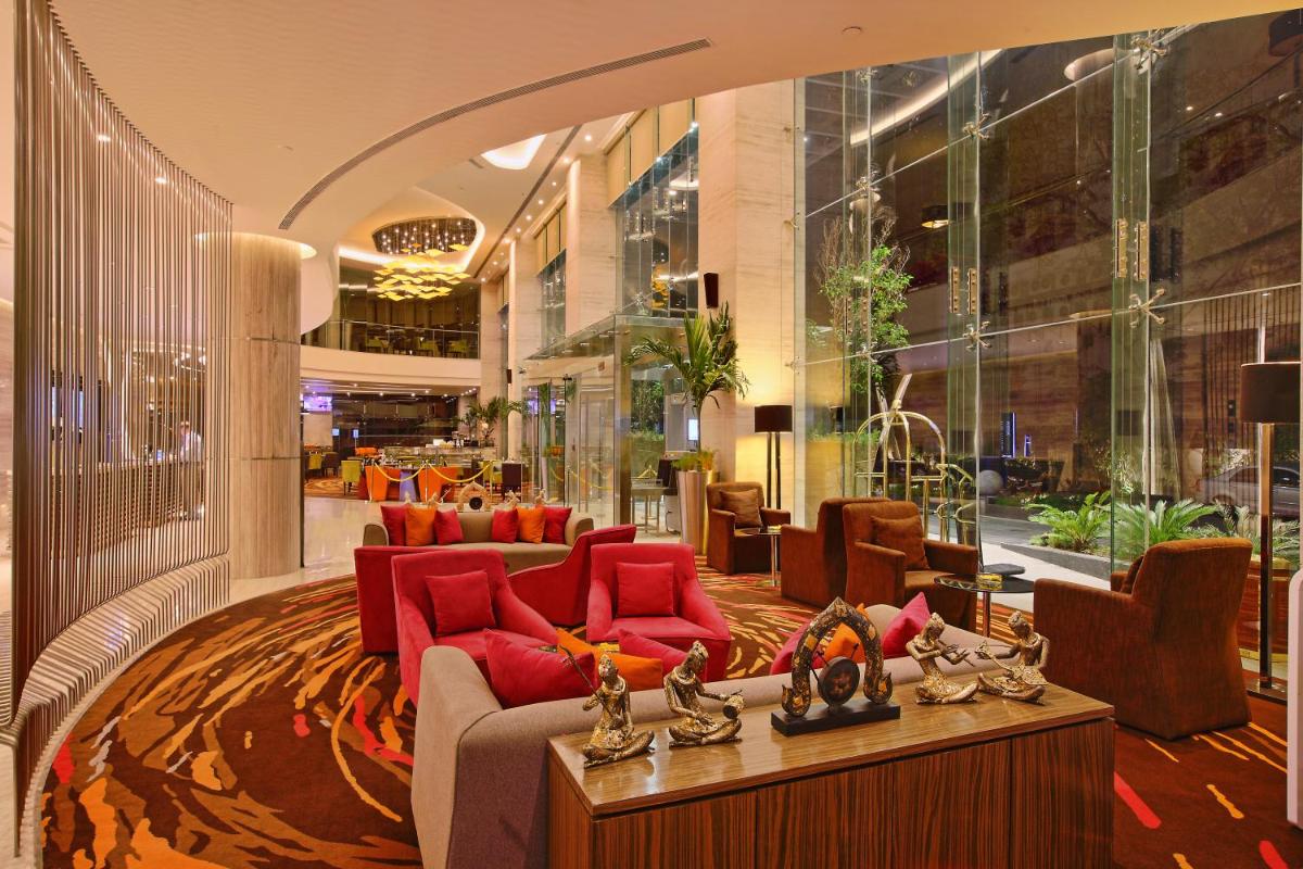 a lobby with red furniture in a building at Novotel Ahmedabad in Ahmedabad