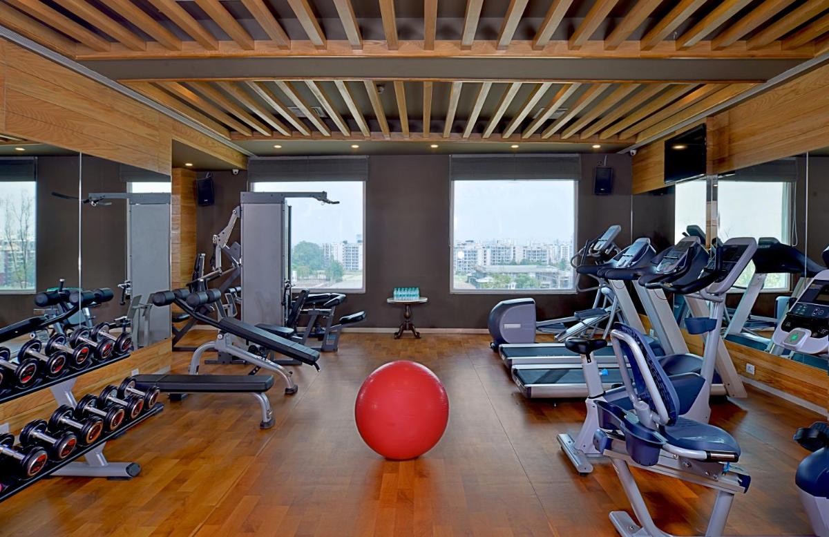 a gym with a bunch of treadmills and a red ball at Radisson Chandigarh Zirakpur in Chandīgarh